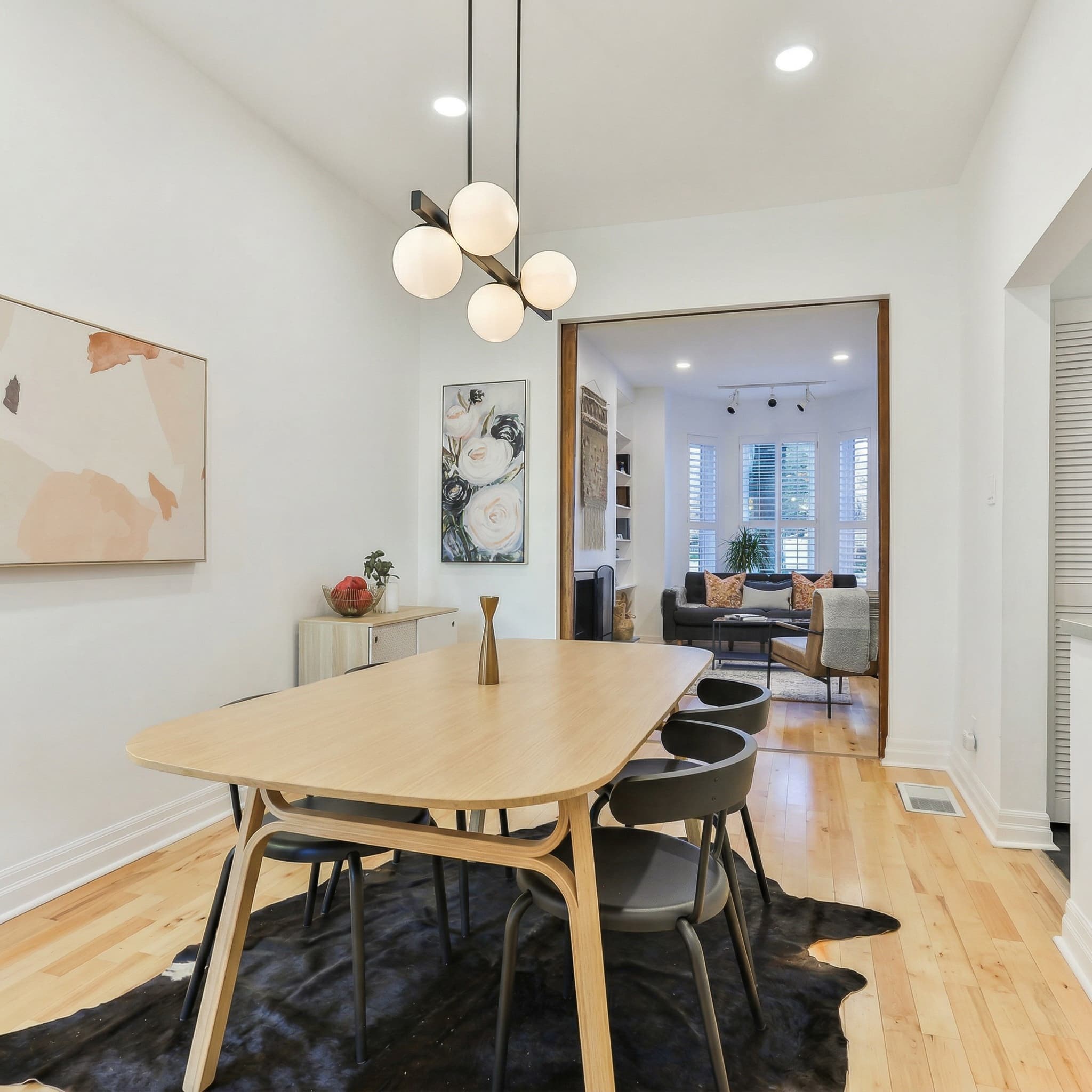 Dining room with globe chandelier and styled table looking into living room — 36 Ford Street
