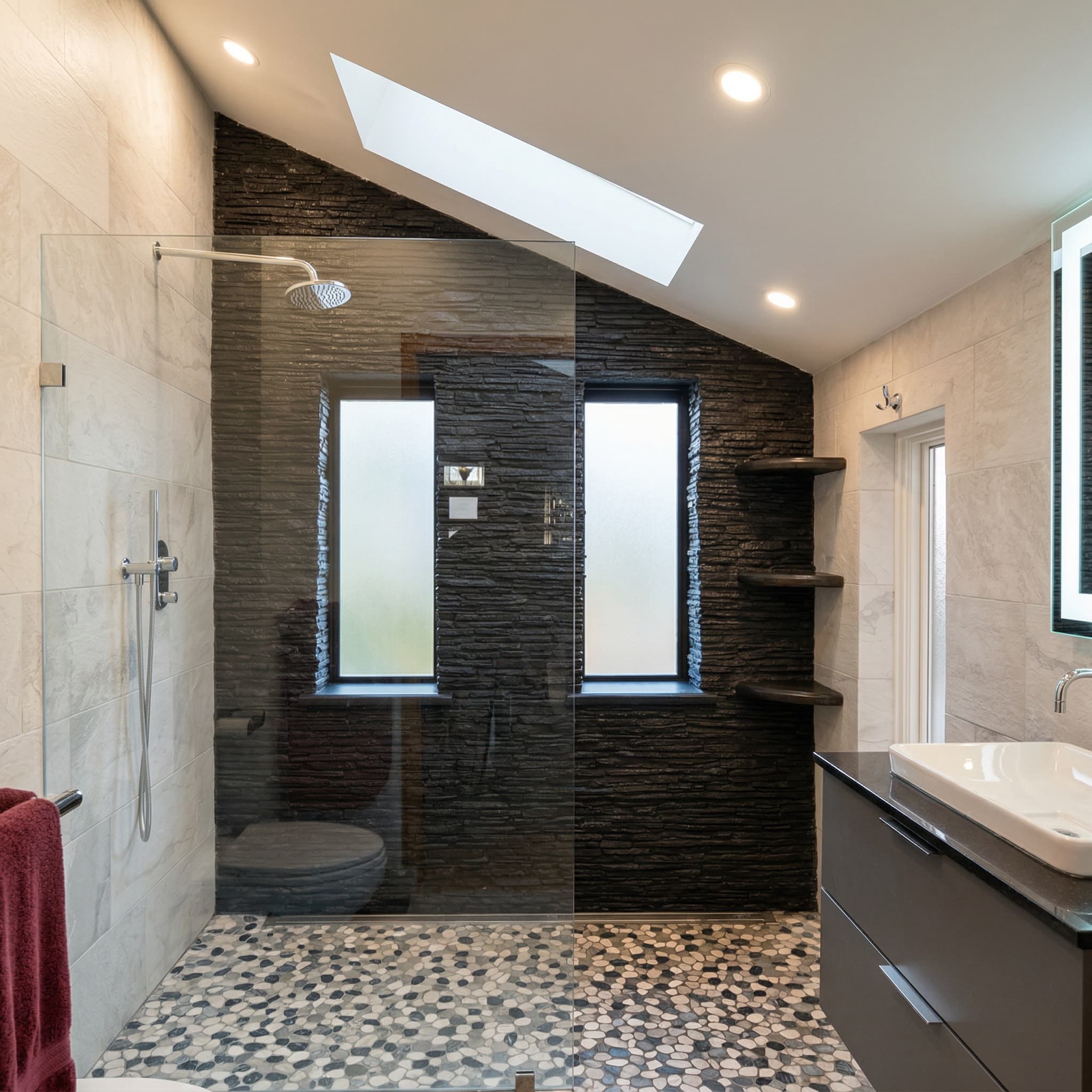 Luxury bathroom renovation with natural stone accent wall and modern fixtures